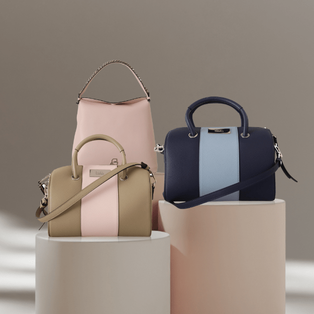 Erilaisia naisten käsilaukkuja: pieni nahkainen olkalaukku, suuri shopper-laukku ja tyylikäs clutch vaaleassa studiotaustassa